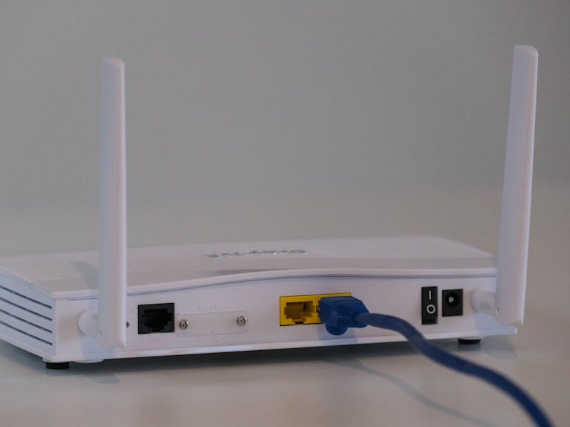 A white Wi-Fi router with an ethernet cable connected.